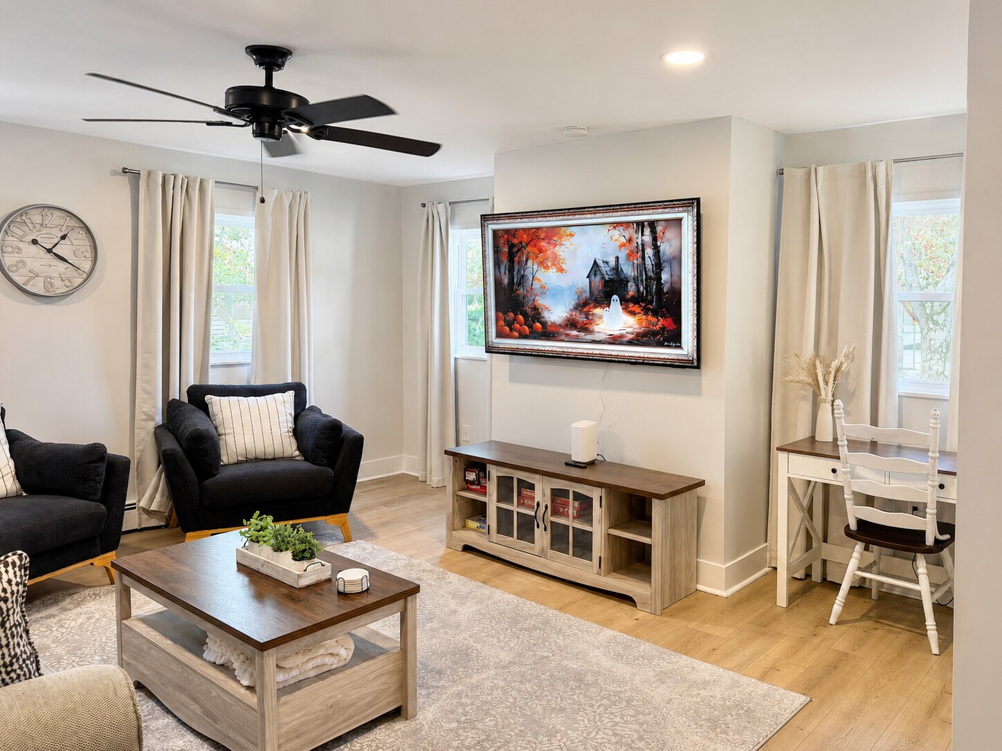 Living room with smart TV, seating and a nearby work nook